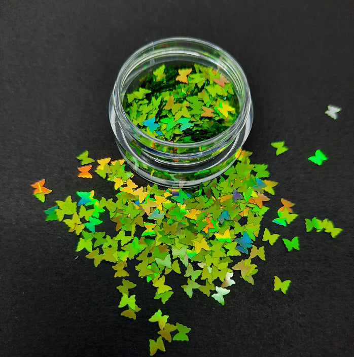 A pot of green holographic butterfly shaped sequins. Used in nail art and also arts and crafts.