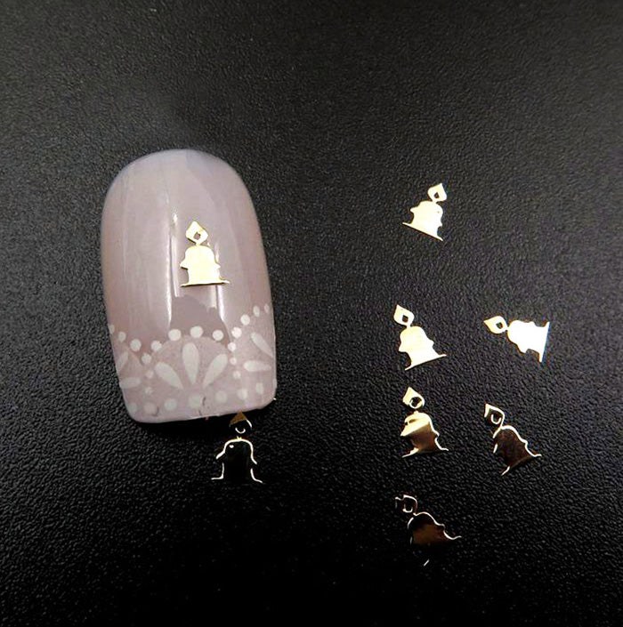 A set of metal nail slices with a Christmas gold candle design, displayed on a dark background.