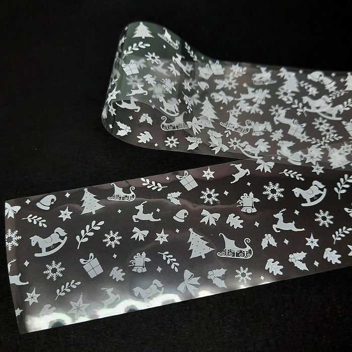 A strip of nail foil with a Christmas theme, featuring holiday motifs such as snowflakes, Santa Claus, and Christmas trees.