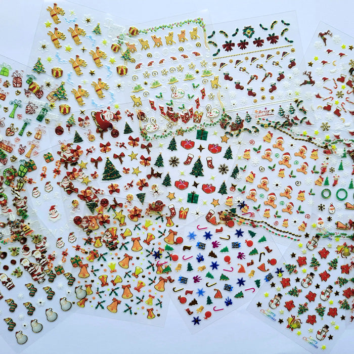 Various embossed Christmas-themed nail stickers spread out on a surface, including designs like Santa Claus, reindeer, and Christmas trees.
