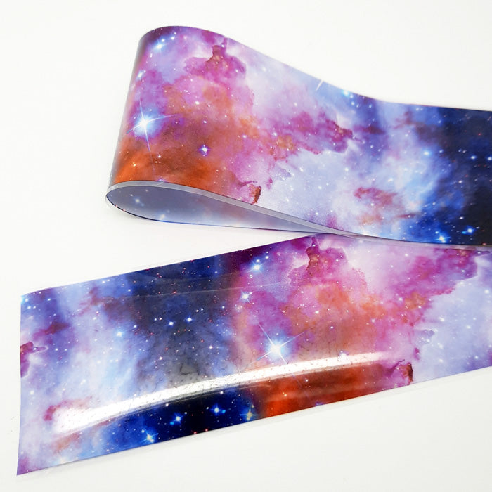 A strip of colourful nail art foil with a design of night sky displayed on a white background.