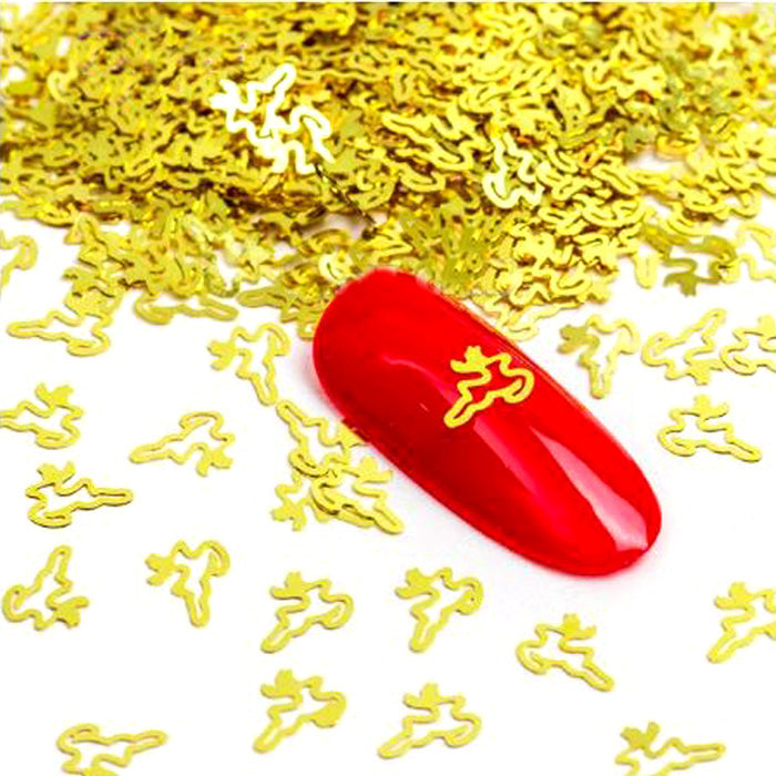 A red nail with a gold reindeer emblem design, surrounded by scattered gold nail slices on a white background.