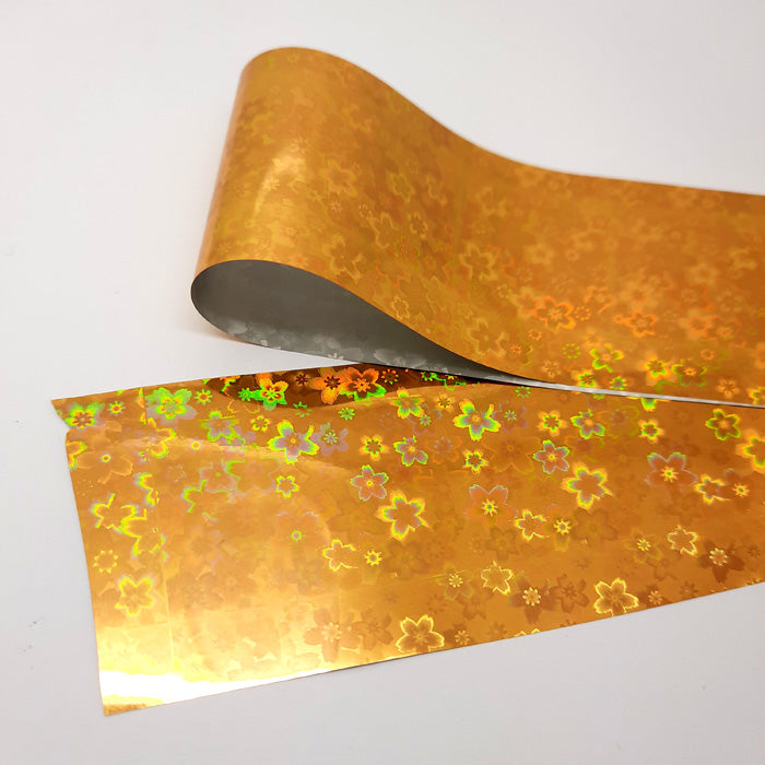 Gold Holo Nail Foil With Flowers, very beautiful, and transfers so easily.
Supplied in 4cm x 100cm lengths.