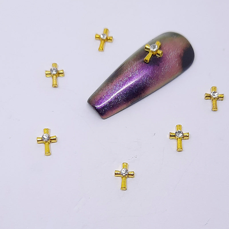 Adorable little gold cross nail charms with a clear gem in the centre.