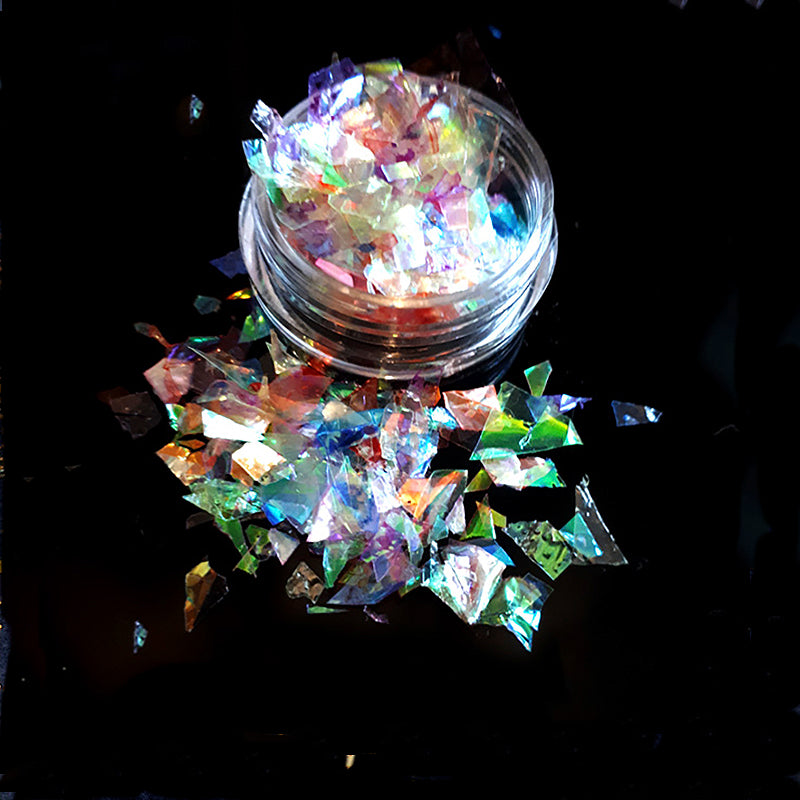 Colourful iridescent glitter in a small round container on a black background