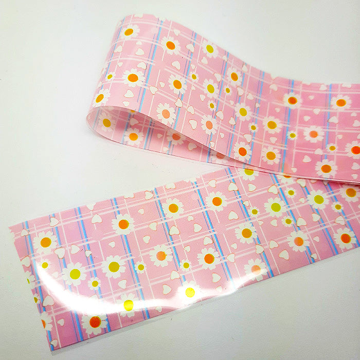 Roll of pink nail foil with colourful patterns on a white background