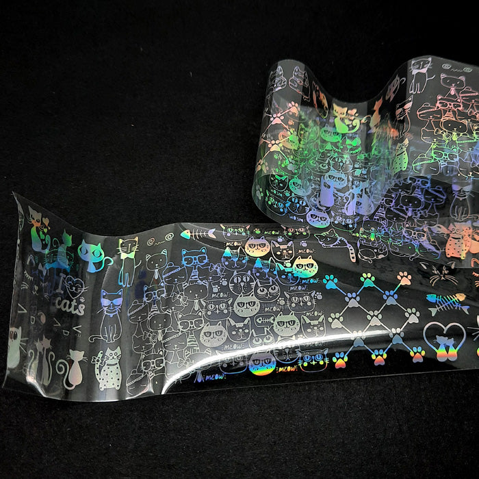 Holo Cats Nail Transfer Foil. An adorable nail foil, covered in silver cats and paw prints on a clear backing.
Supplied in 4cm x 100cm lengths.