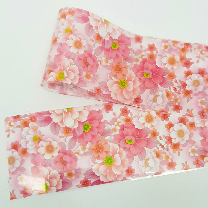 A strip of pink floral nail foil on a white background