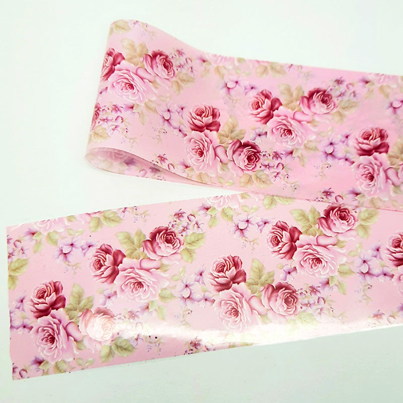 Roll of pink floral nail art foil with roses on a light green background