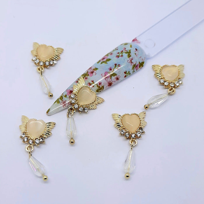 The most beautiful winged heart nail charms, embedded with gems and with a larger gem dangling from the base.