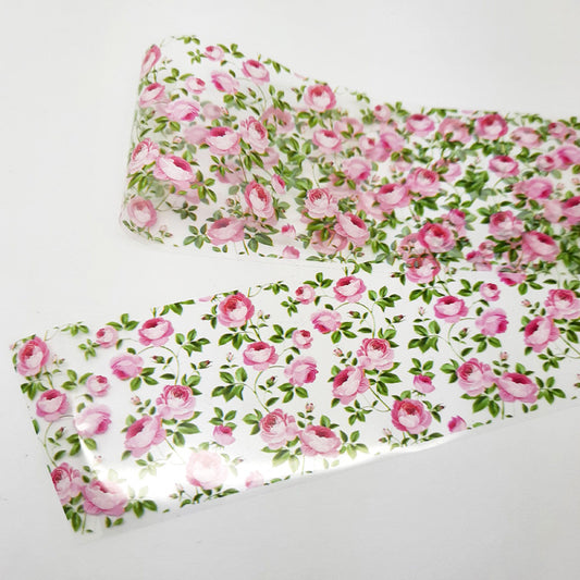 Floral-patterned nail art foil with pink roses and green leaves on a white background