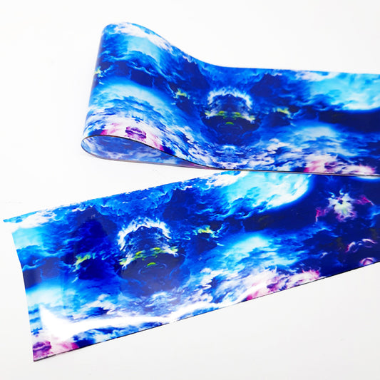 A strip of nail art foil with a design of blue clouds displayed on a white background.