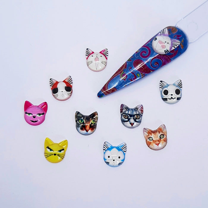 Colourful cat face nail art charms on a white background