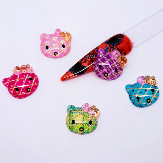 Colourful Hello Kitty nail art charms with a nail tip on a white background