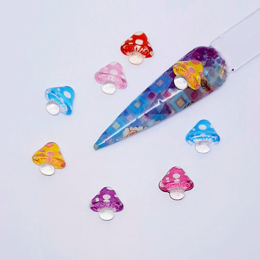 Colourful resin mushrooms on a light grey background, used in nail art