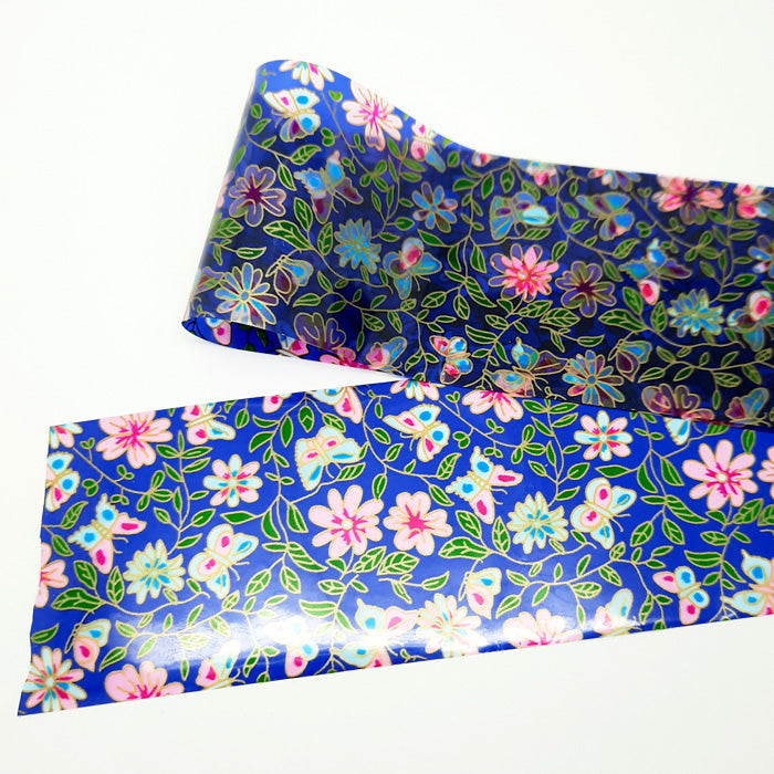 A strip of blue nail foil with a floral and butterfly design, on a white background.