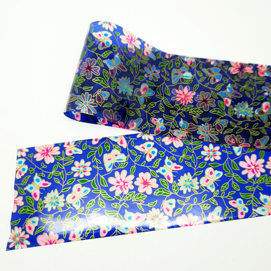 A strip of blue nail foil with a floral and butterfly design, on a white background.