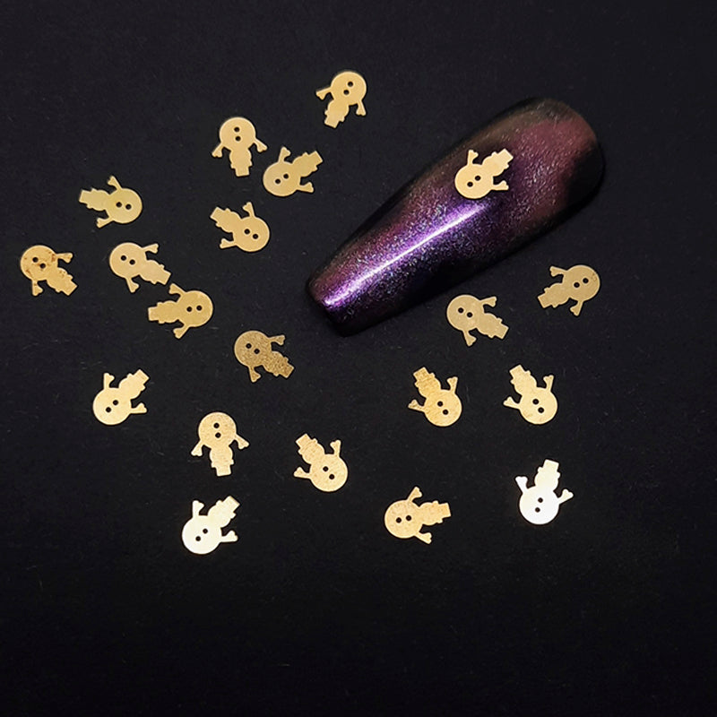 Purple glittery nail tip with gold snowman nail decorations on a black background