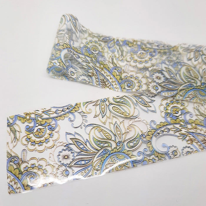 Patterned nail art foil with blue and gold design on a white background