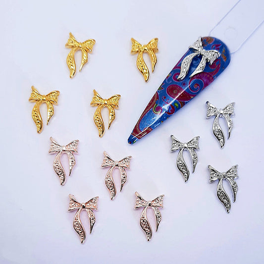 Collection of decorative nail art charms with bow designs on a white background