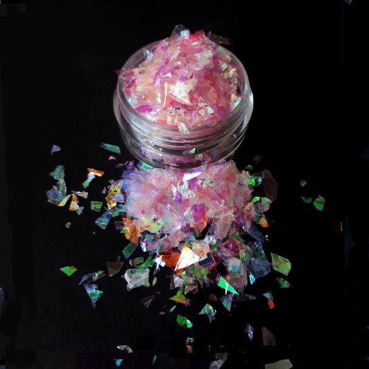 a pot of pink nail flakes on a black background