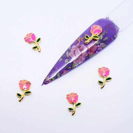 Floral-themed nail art charms with pink rose designs on a white background