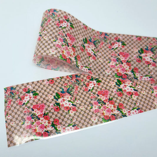 Floral patterned nail art foil with Gucci logo on a light grey background