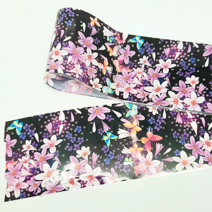Roll of floral and butterfly patterned nail foil on a white background