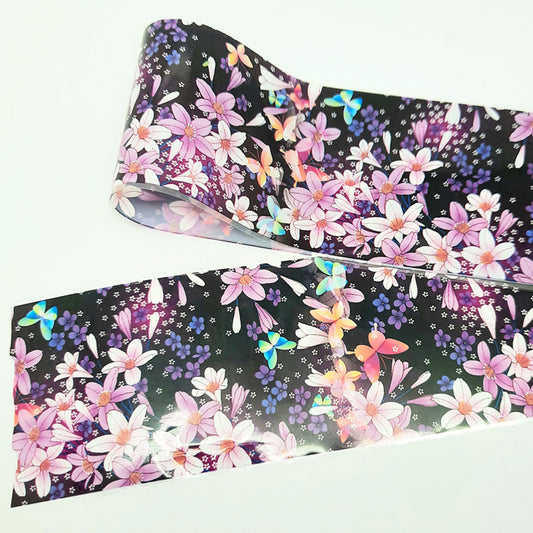 Roll of floral and butterfly patterned nail foil on a white background