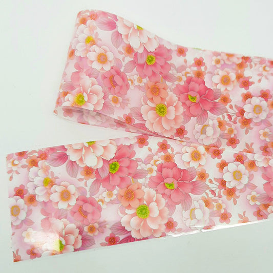 A strip of pink floral nail foil on a white background