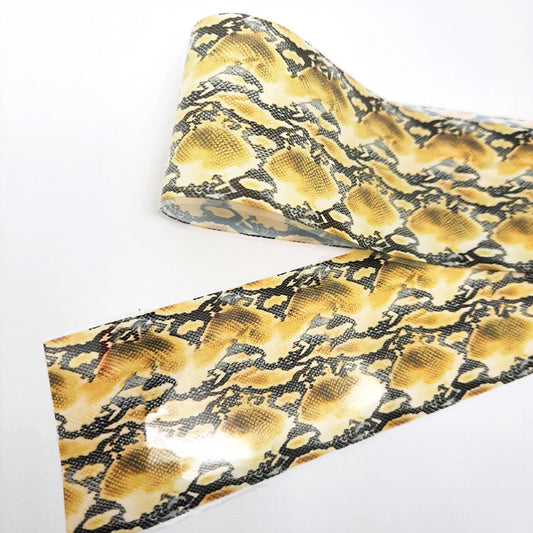 A strip of nail art foil with a snakeskin design displayed on a white background.