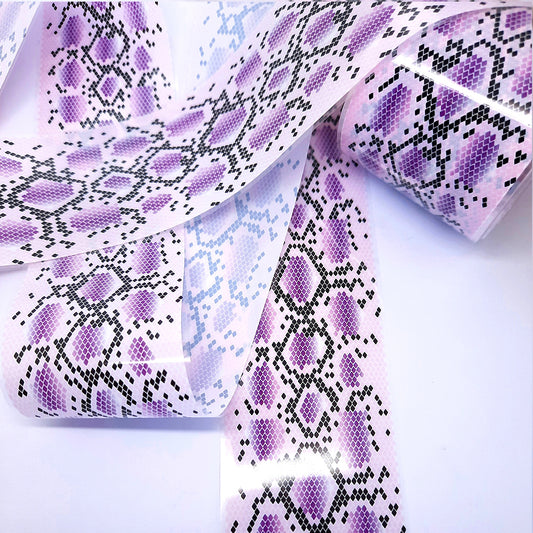 Roll of purple and black patterned nail art foil on a white background